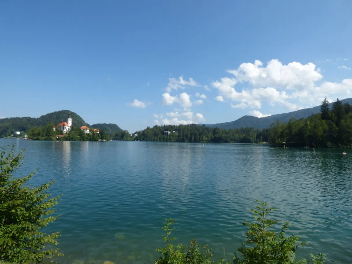 Calm lake and its island under a sky of white clouds