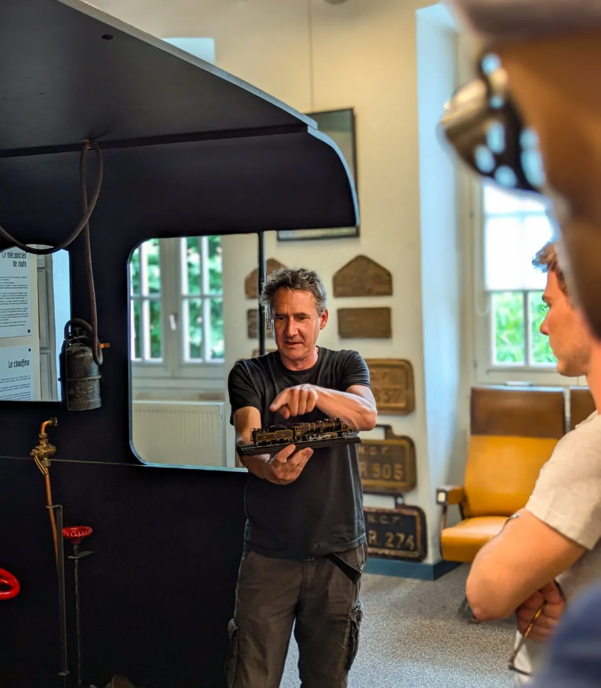 Guide presenting locomotive plates in front of a black engine