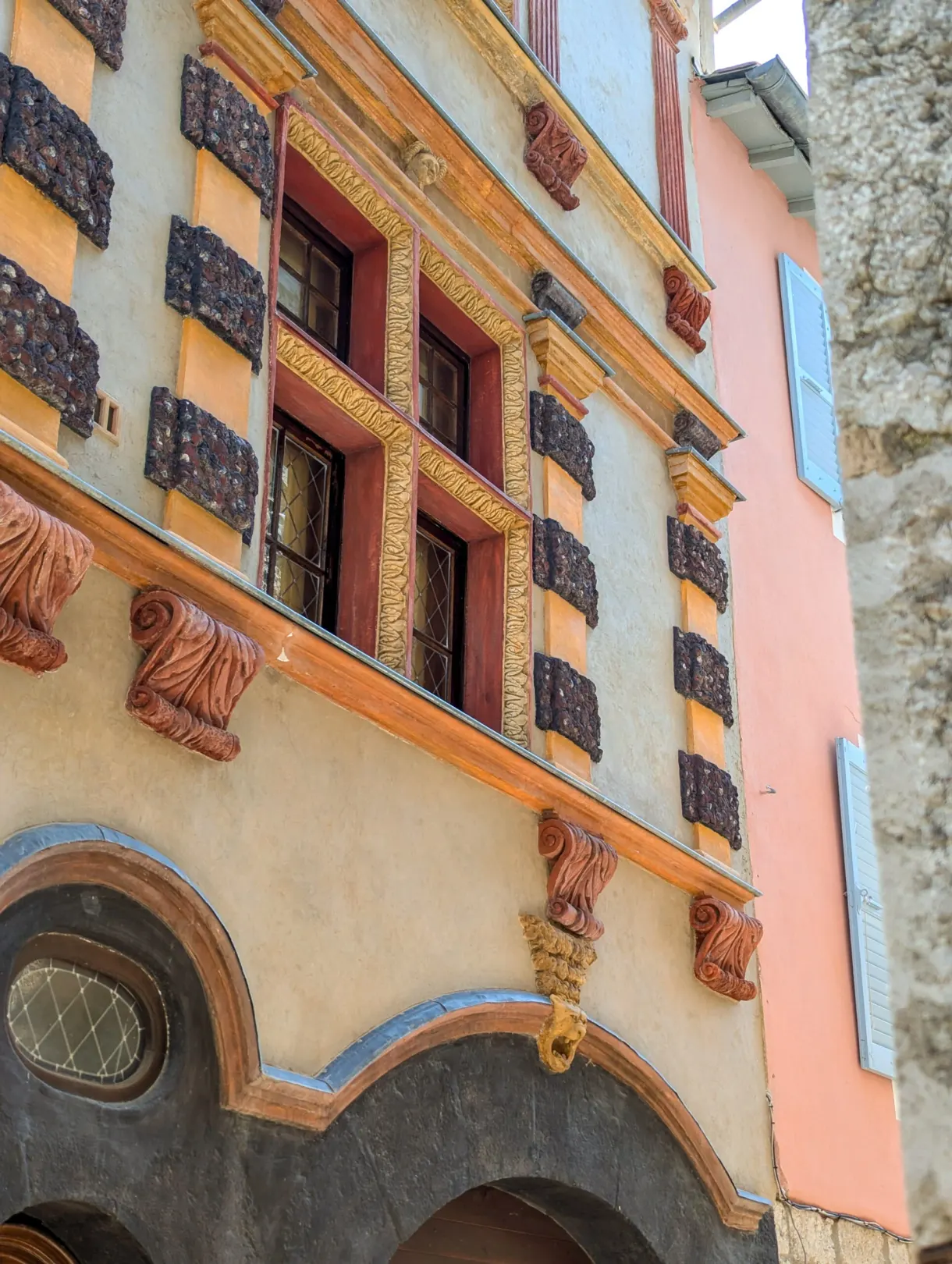 Detail of a trompe l'oeil painted facade with red surrounds