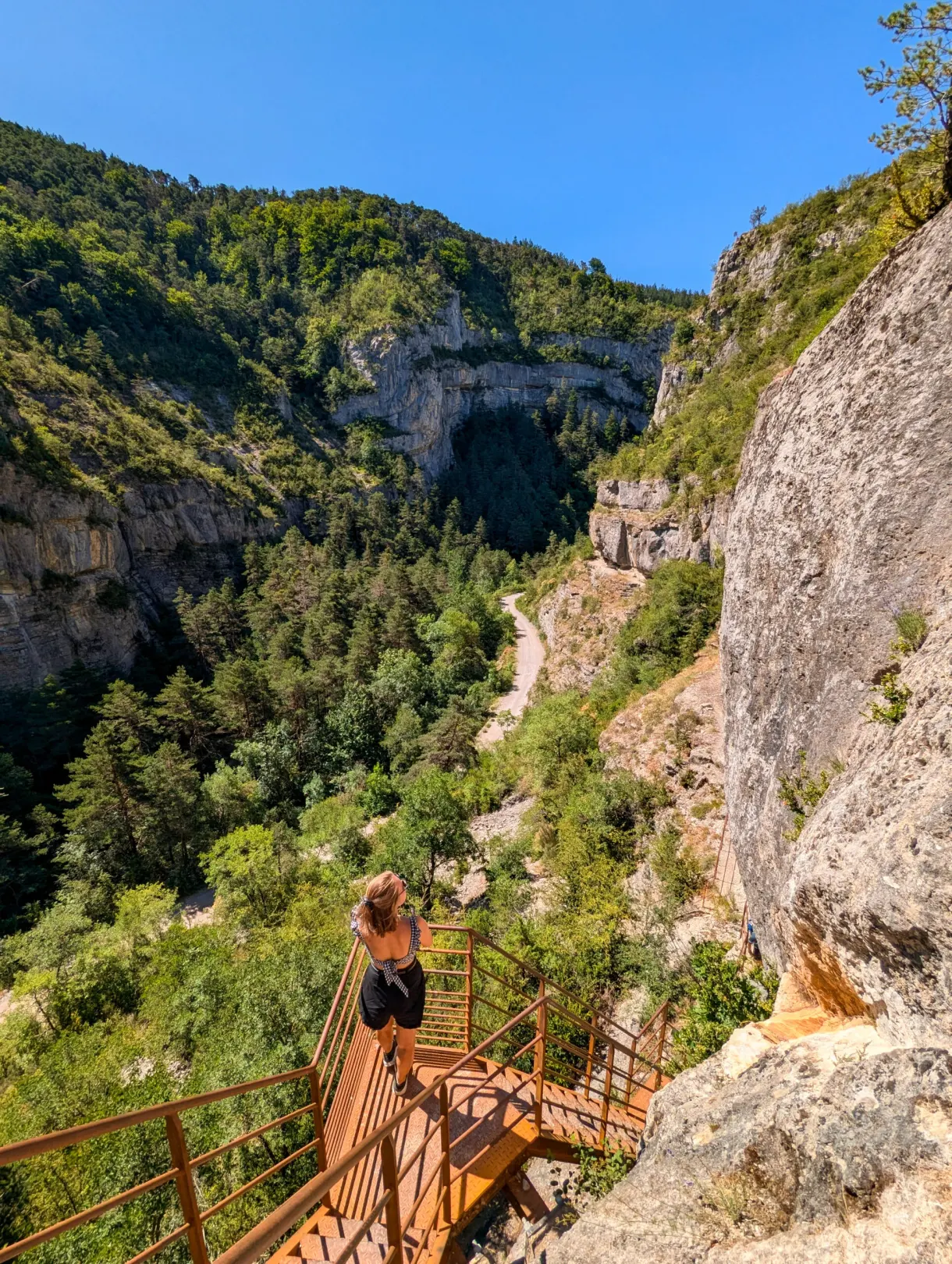 Hiker coming down the metal staircase fixed to the cliff