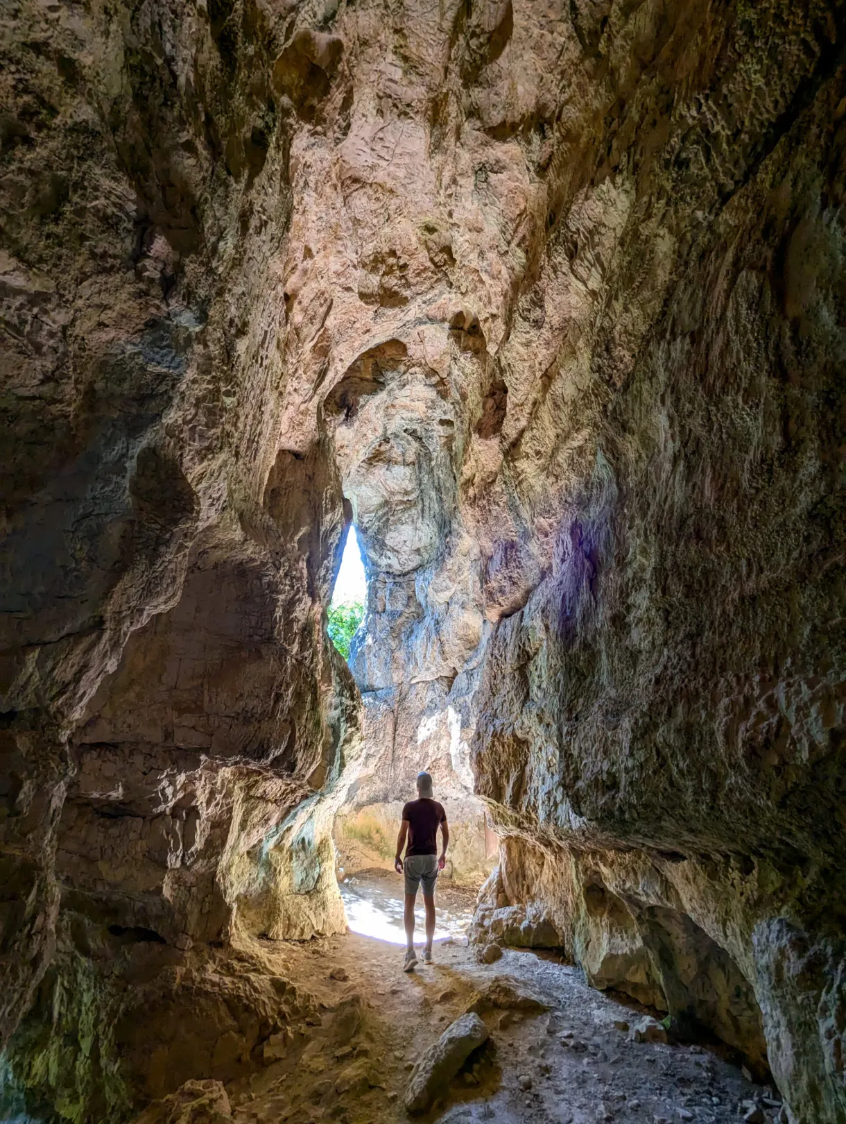 Silhouette of a walker in the vast lit cave