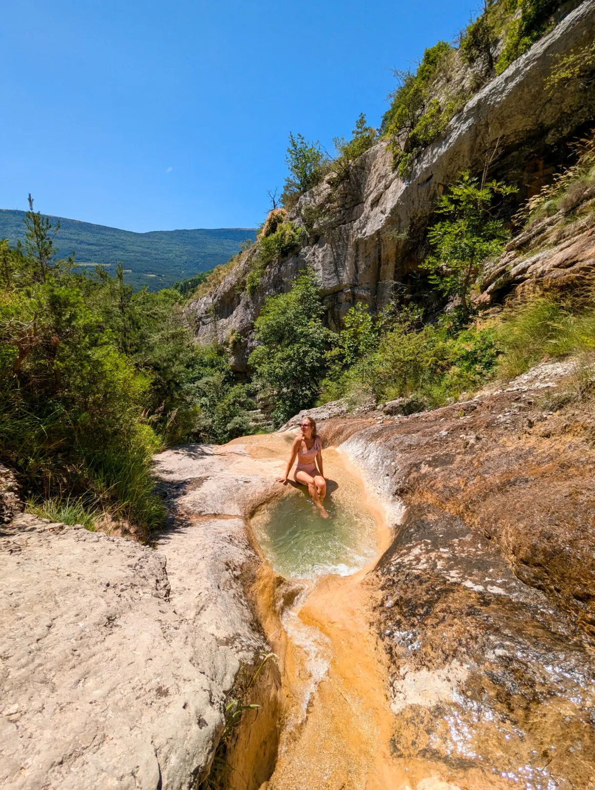 Marie in a natural pool at the foot of the cliffs, in the Sources du Buëch area