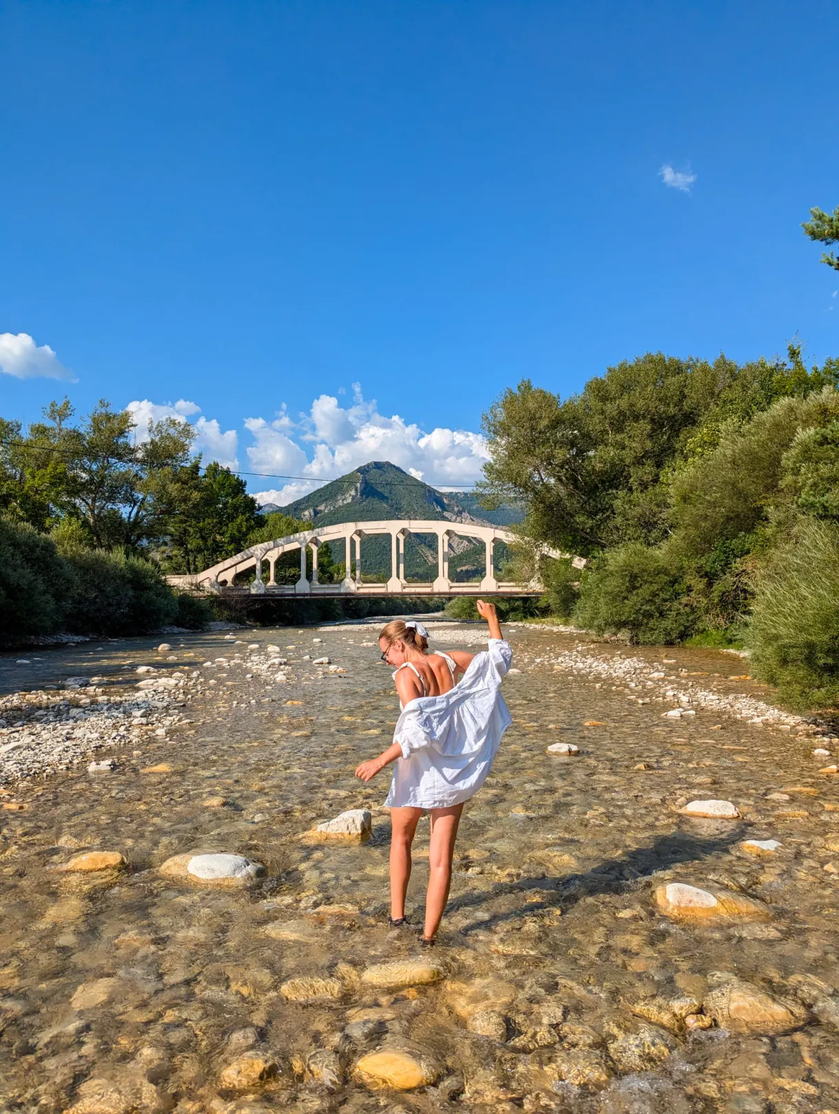 Bather standing on the pebbles of the river bed