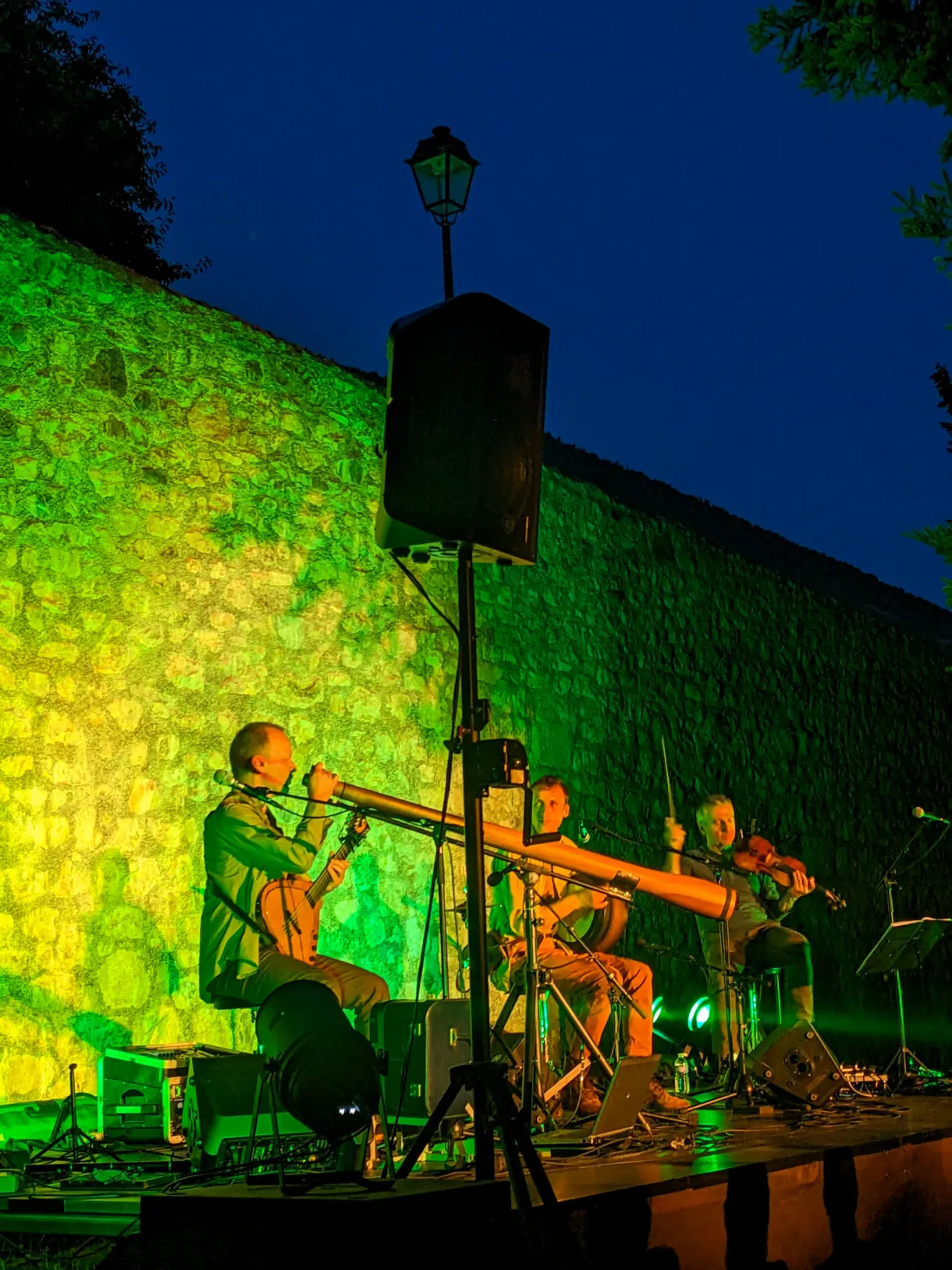 Musicians lit in green during an open air concert