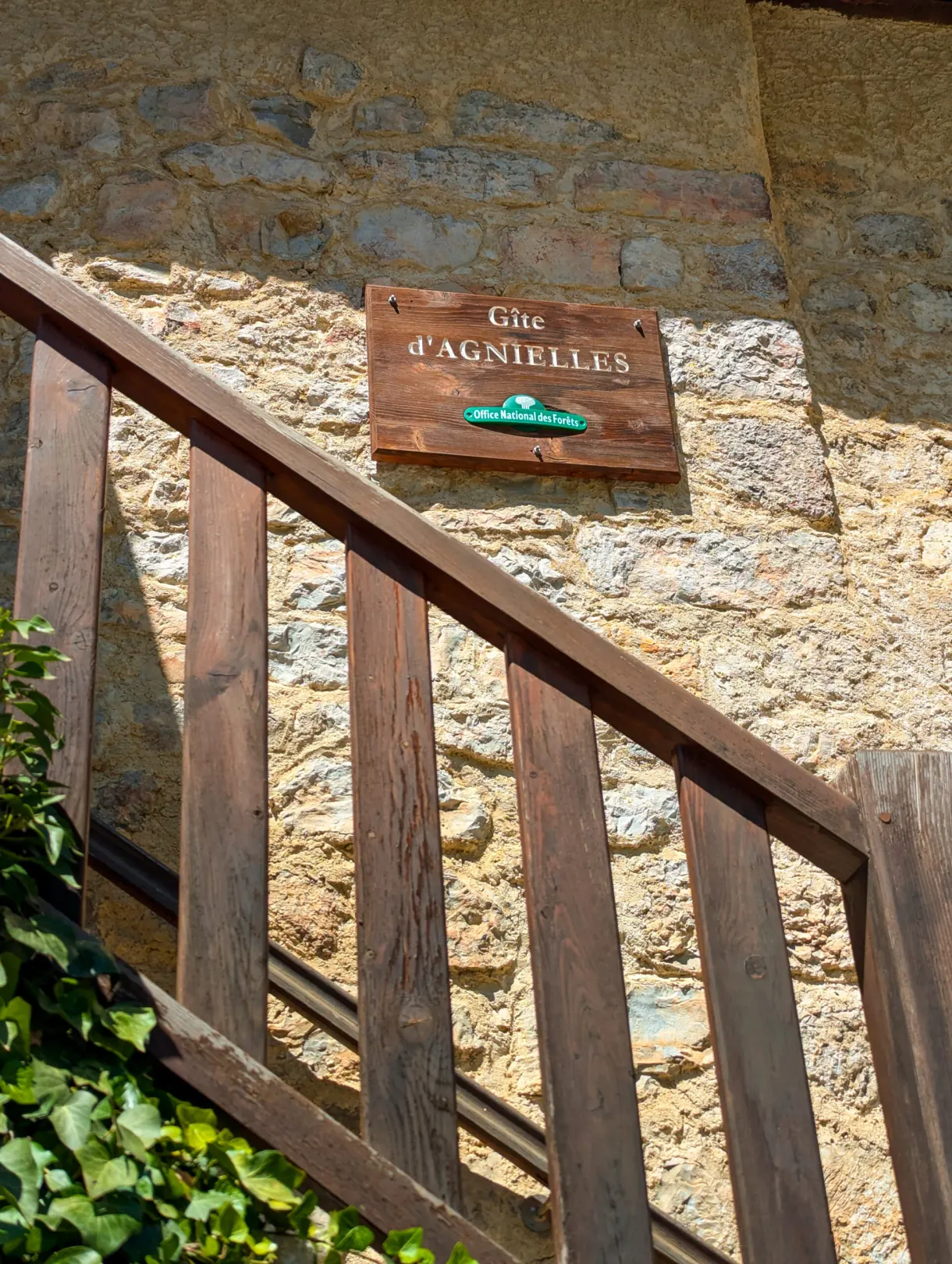 Sign of the gîte d'Agnielles above a wooden staircase
