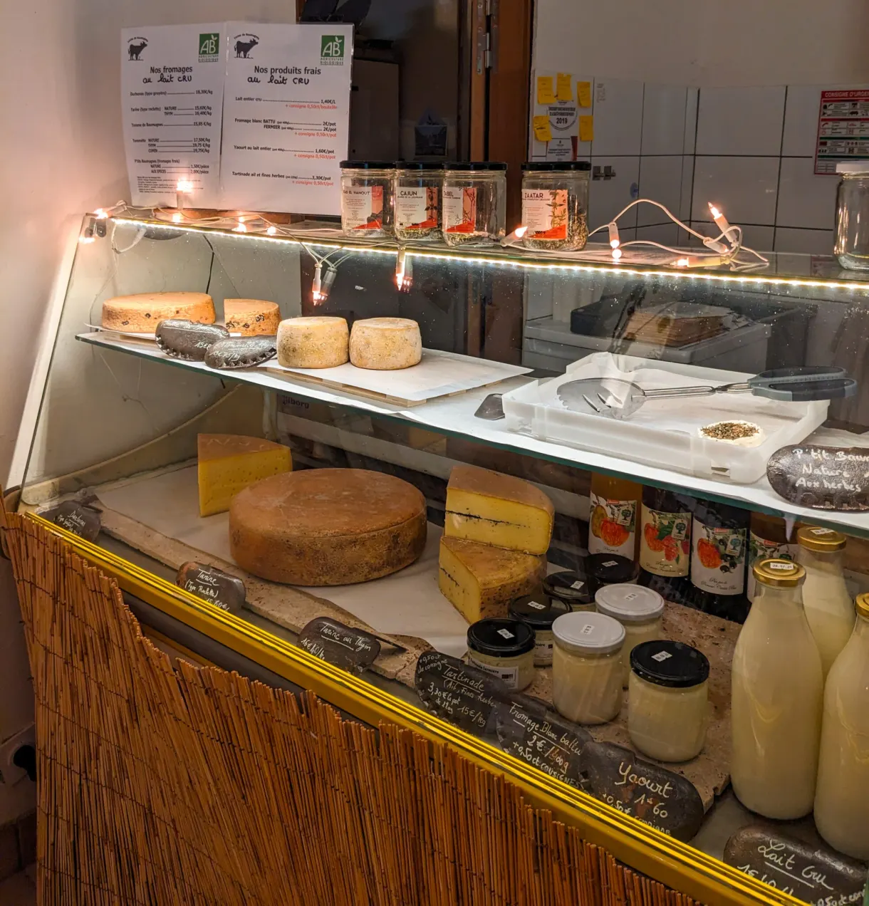 Refrigerated display filled with wheels, tommes and pots of milk