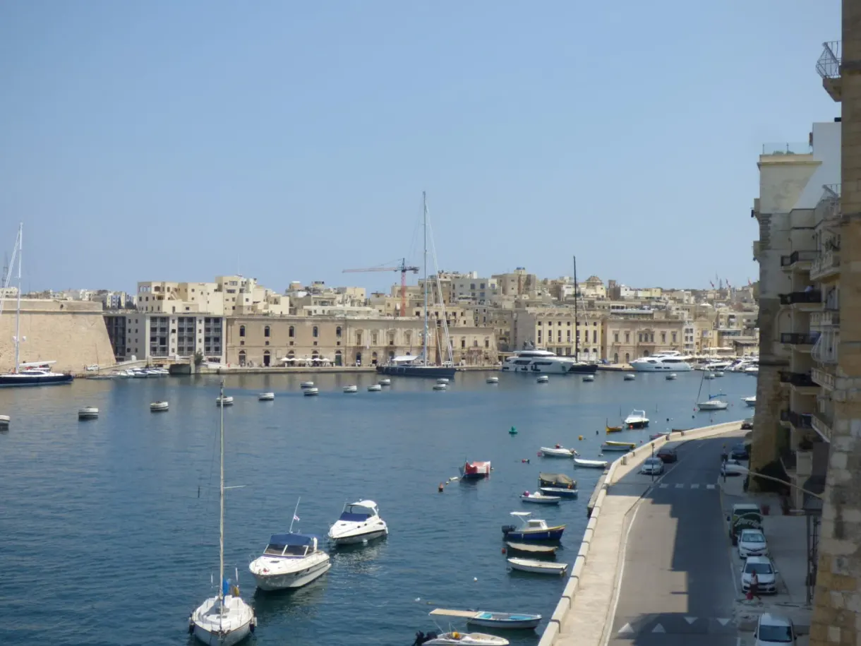 Quay lined with stone houses and boats at anchor