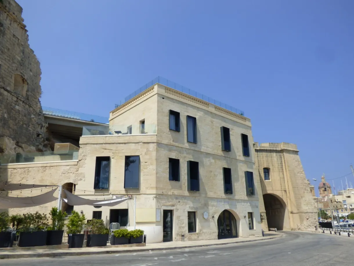 Pale stone building set against the city wall