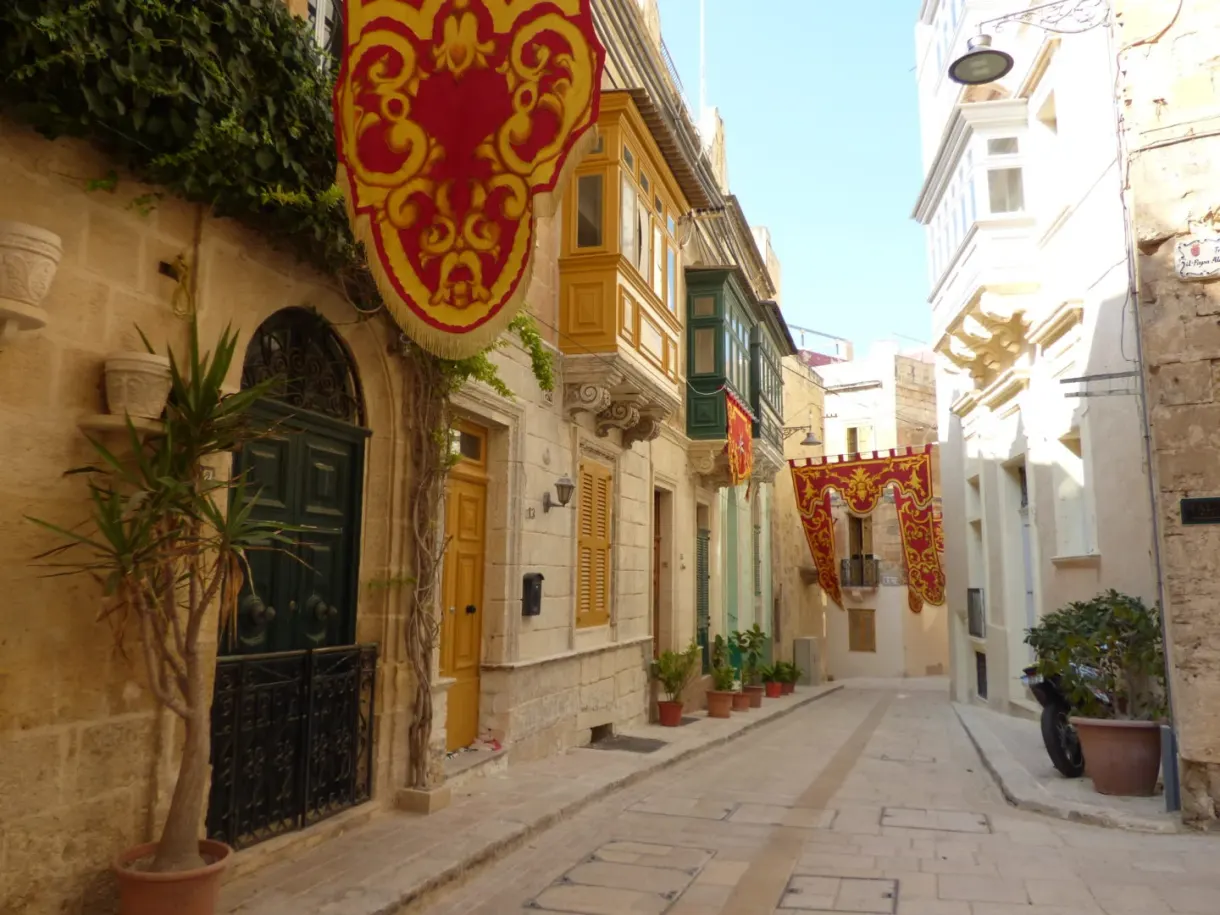 Sloping lane decked with drapes and enclosed balconies