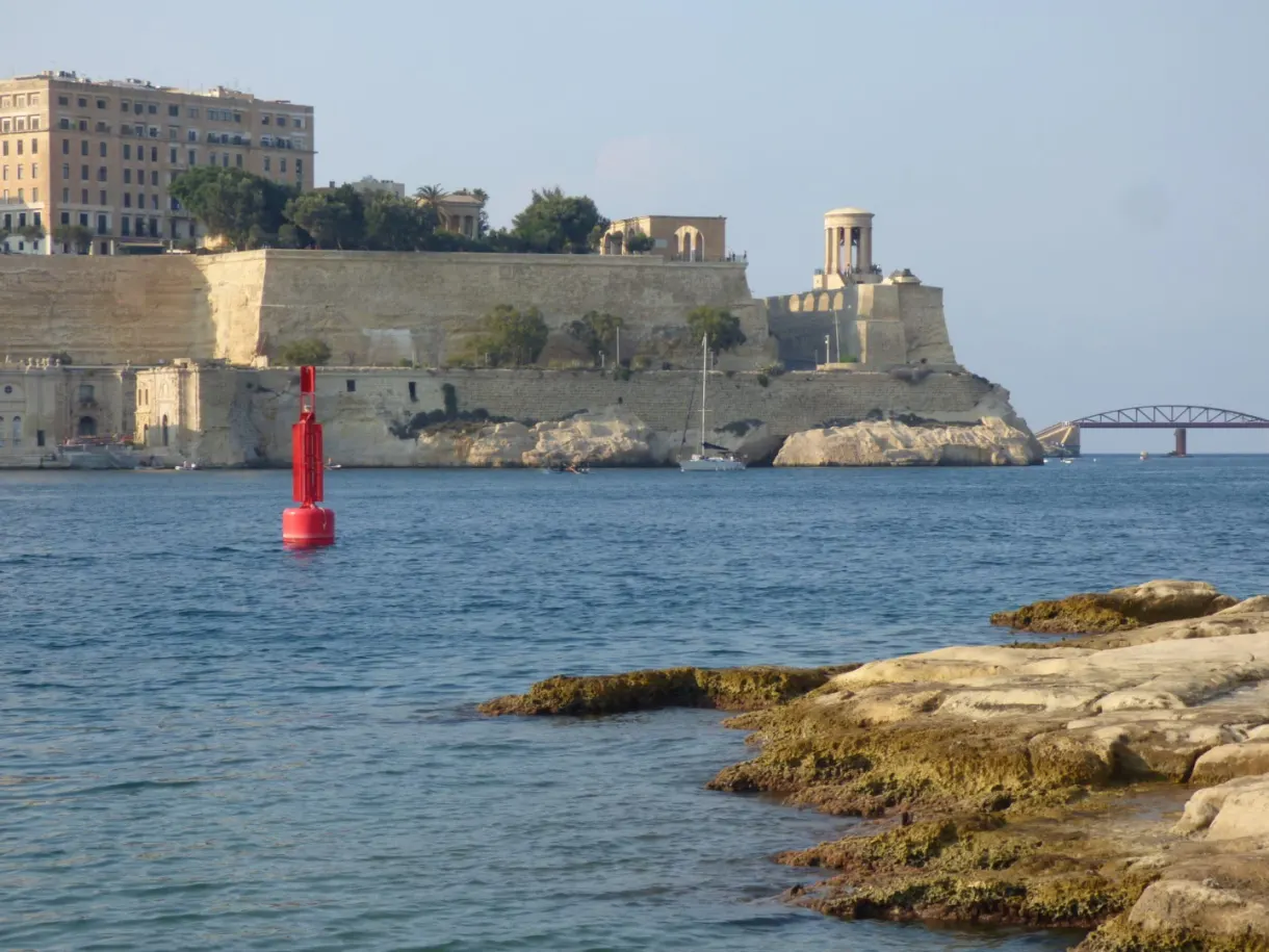 Fortified point and red buoy just above the rocks