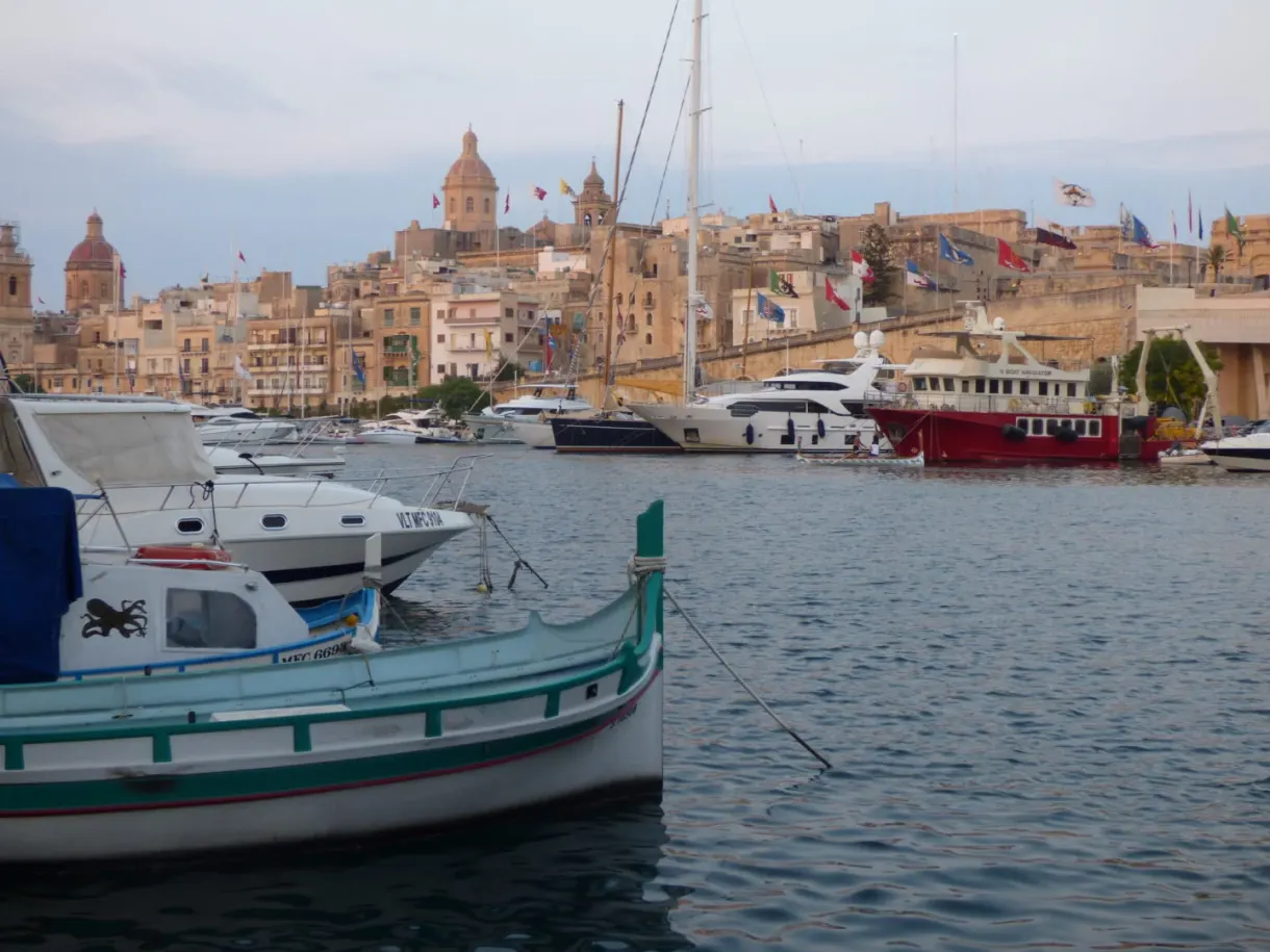 Maltese boat in front of the domes and the golden facades