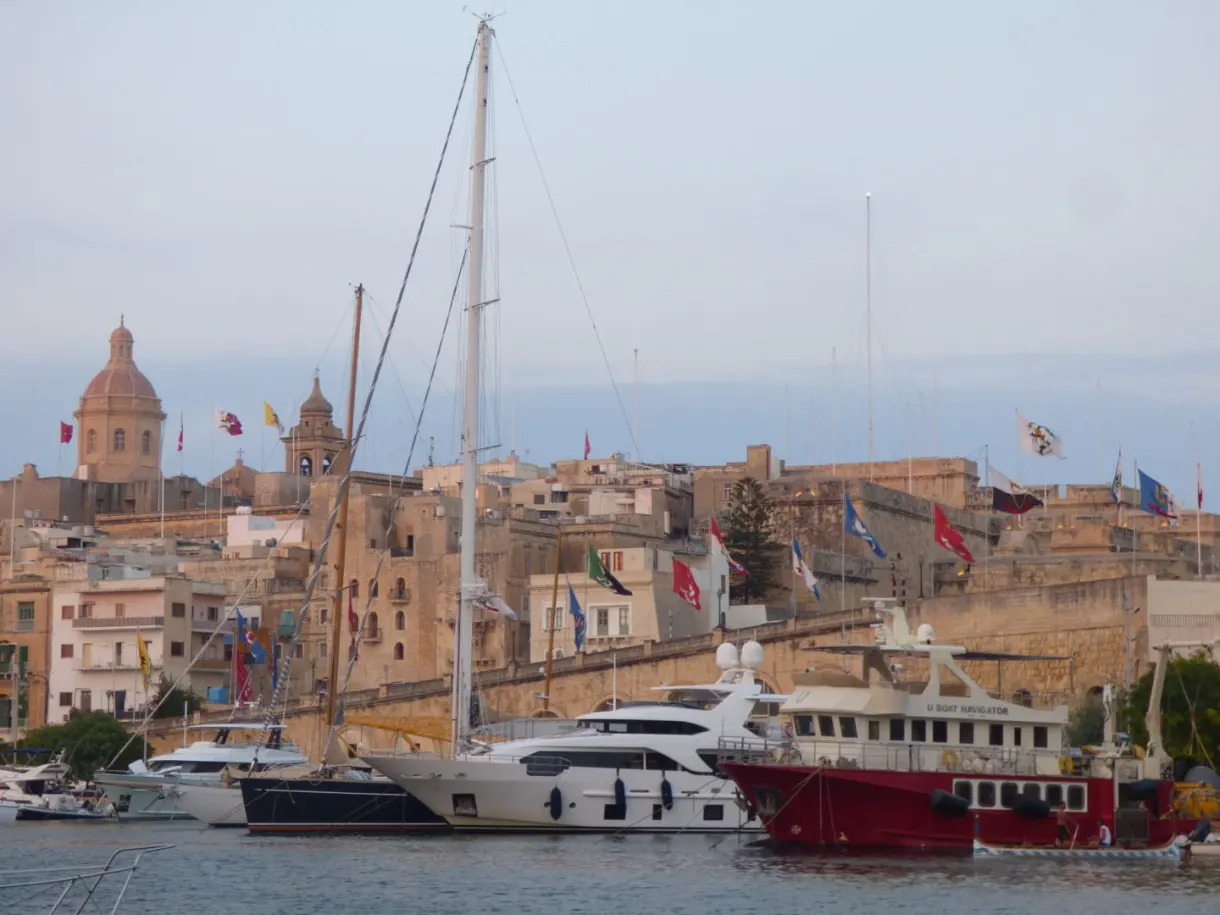 Sailing boats moored in front of the flag-decked domes