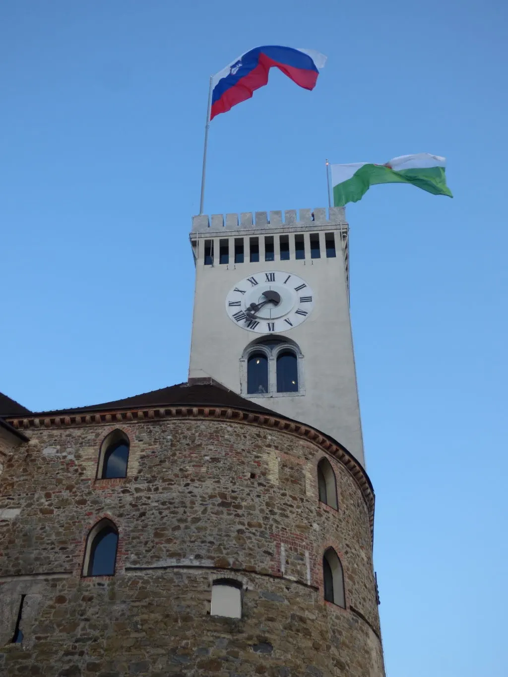 White watchtower and Slovenian flags seen from below
