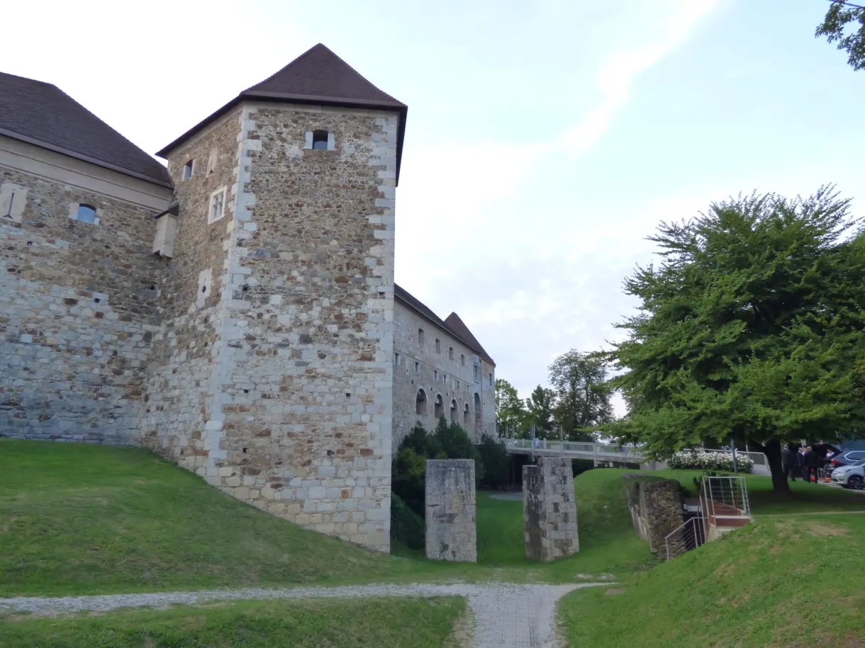 Crenellated tower with a red roof on the lawn inside the walls