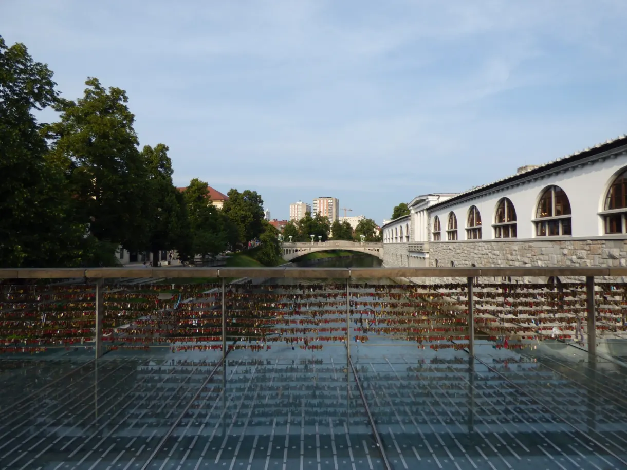 Footbridge covered in padlocks in front of the arcaded market halls