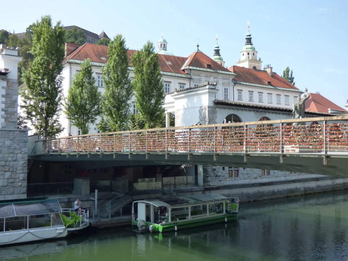 Tour boat moored under a metal bridge over the Ljubljanica