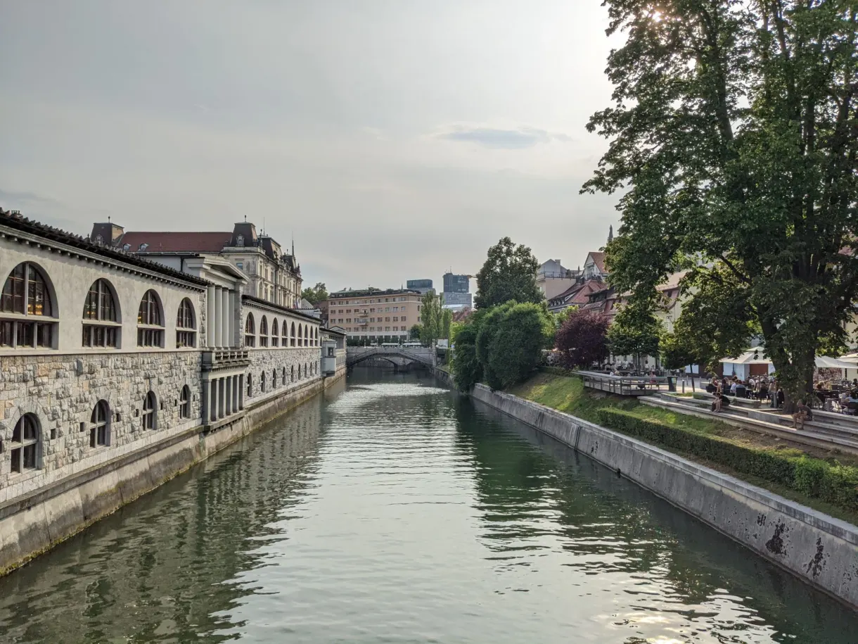 Covered market halls running along the green water of the river