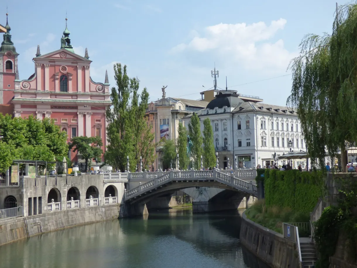 Pink church and white bridge reflected in the green water