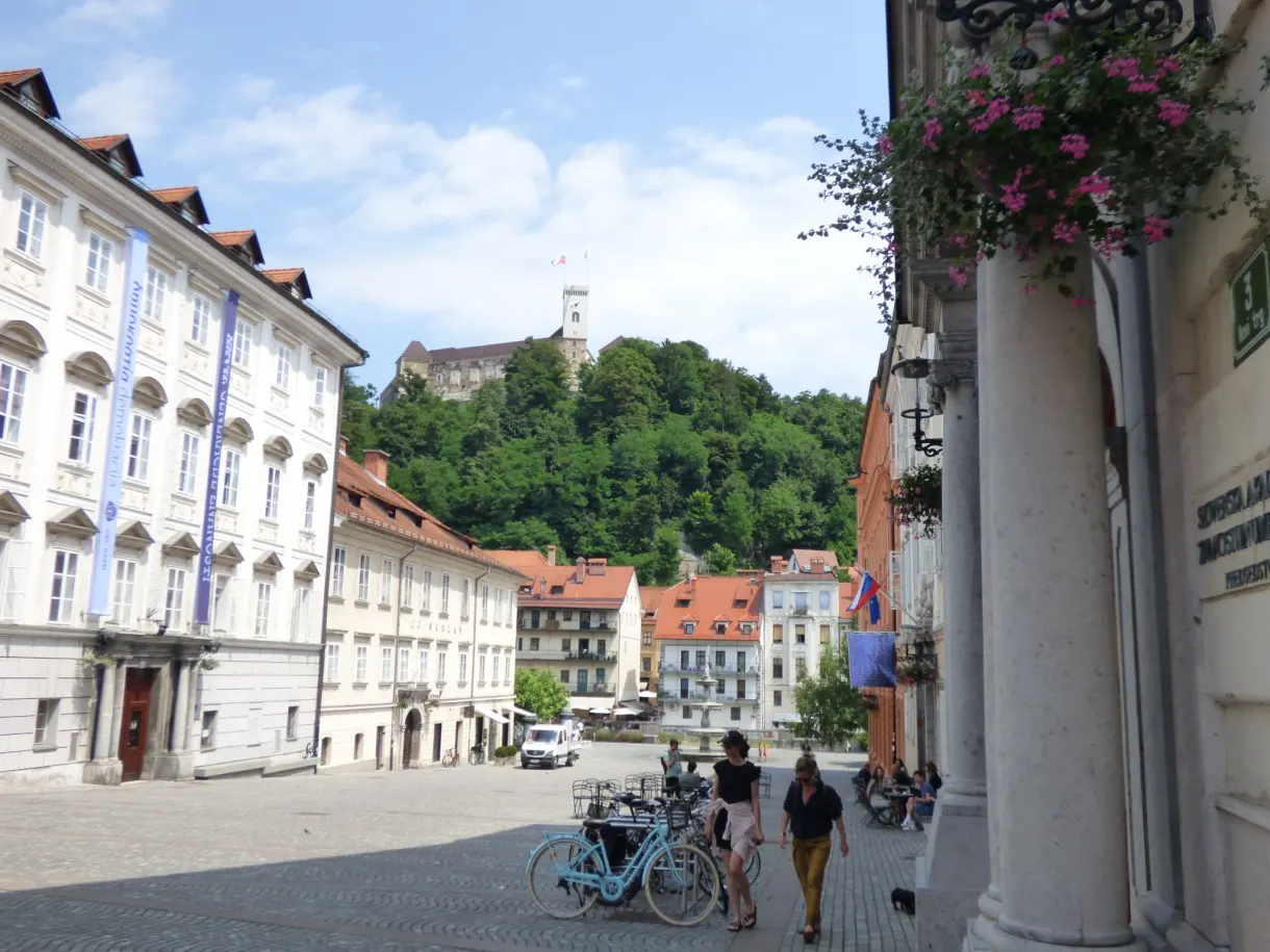 Square lined with pale palaces, castle hill at the far end