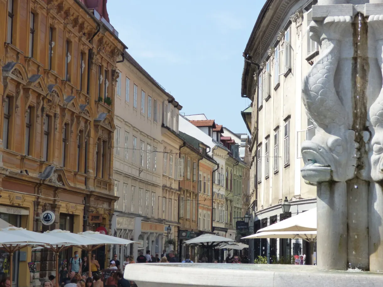 Carved fountain and terraces with white parasols between the palaces