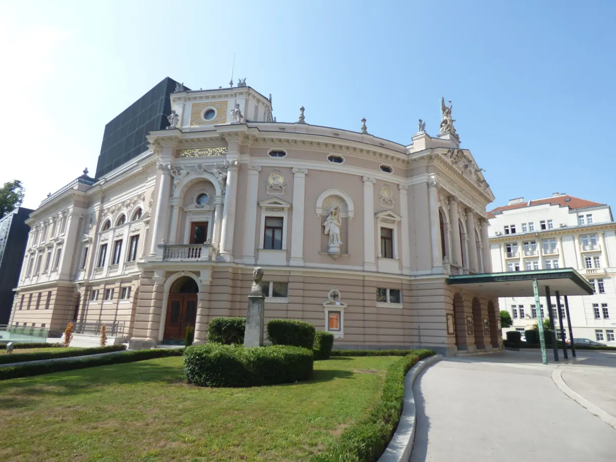 Pale neo baroque theatre in front of its trimmed lawn
