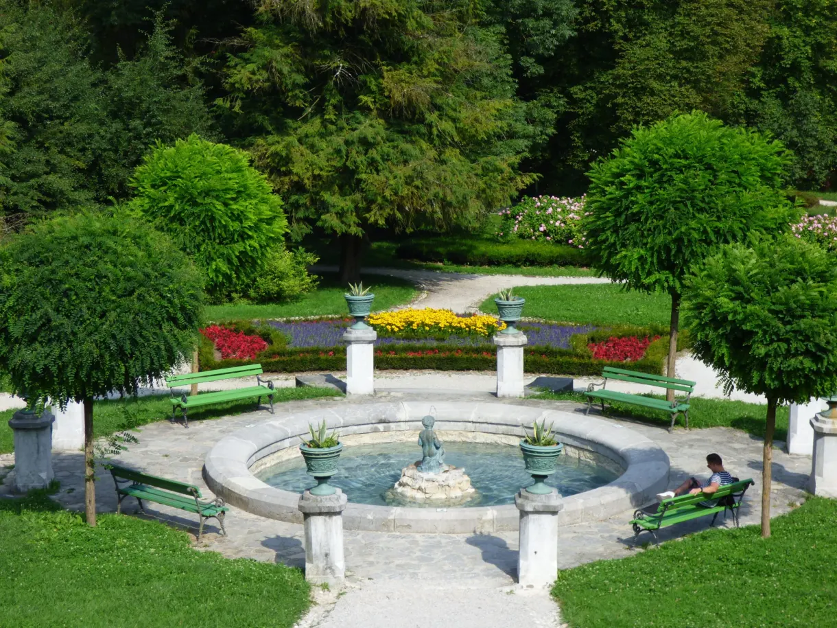 Round pond and flower beds between the green benches
