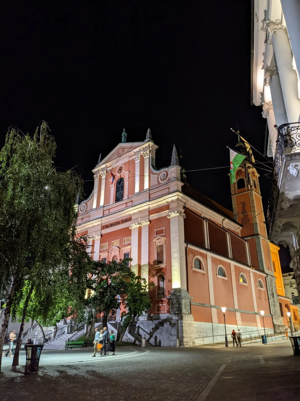 Pink church lit up at night above the steps