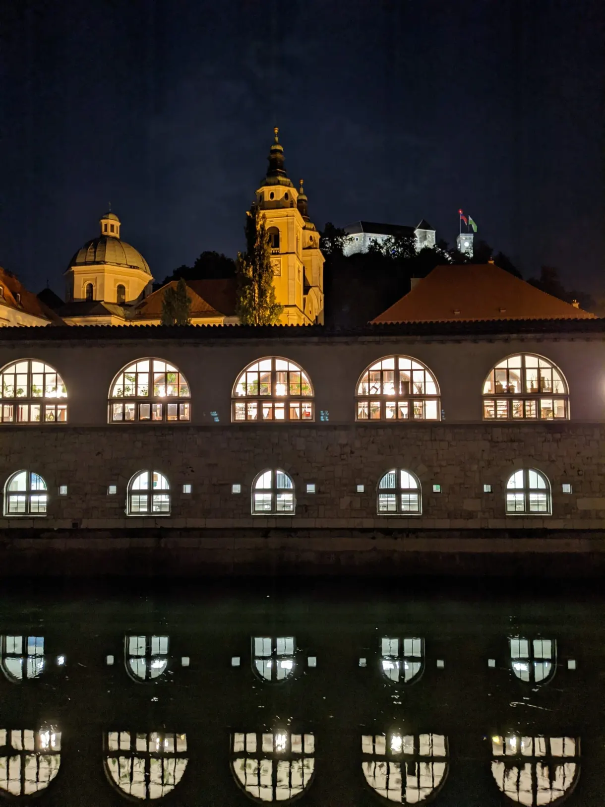Arcades of the market halls doubled by their reflection in the black water