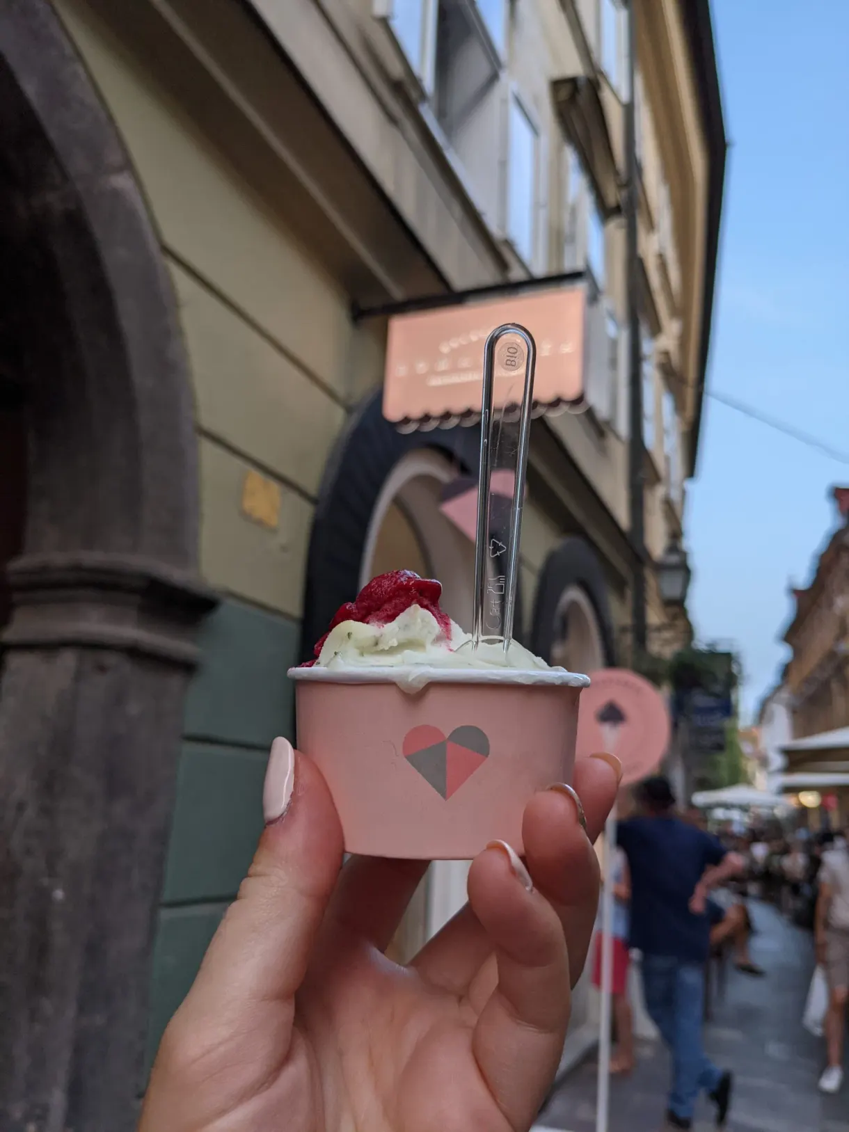 Ice cream served in a pink tub held up in the street