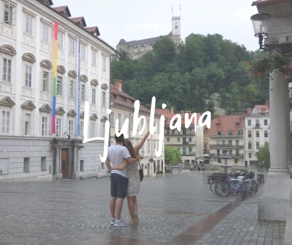 Couple from behind on a paved square, castle at the top of the hill