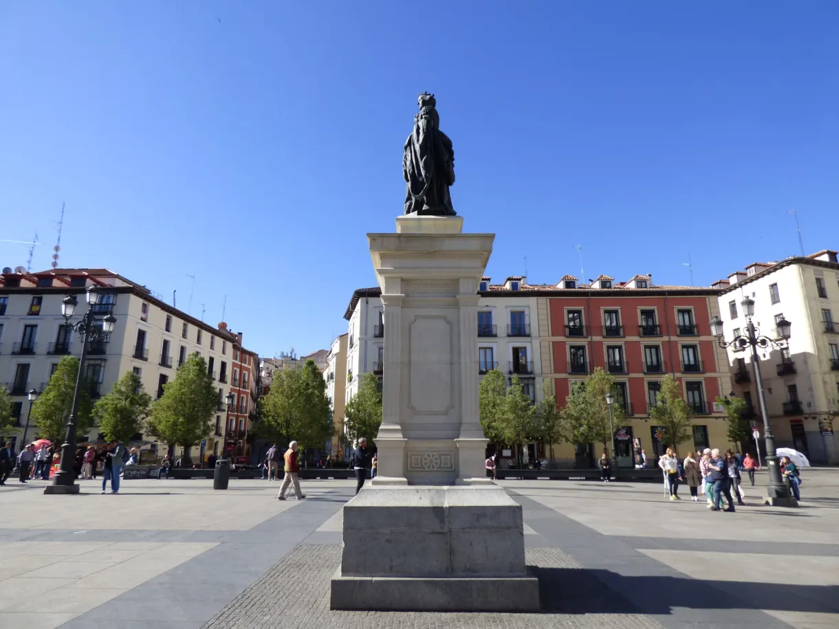 Statue on its tall plinth in the middle of a sunlit square