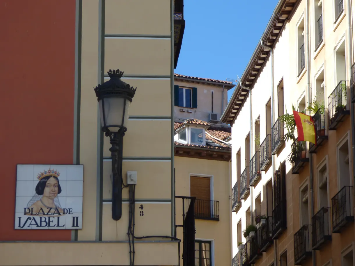 Ceramic plaque of the Plaza de Isabel II on a pale wall