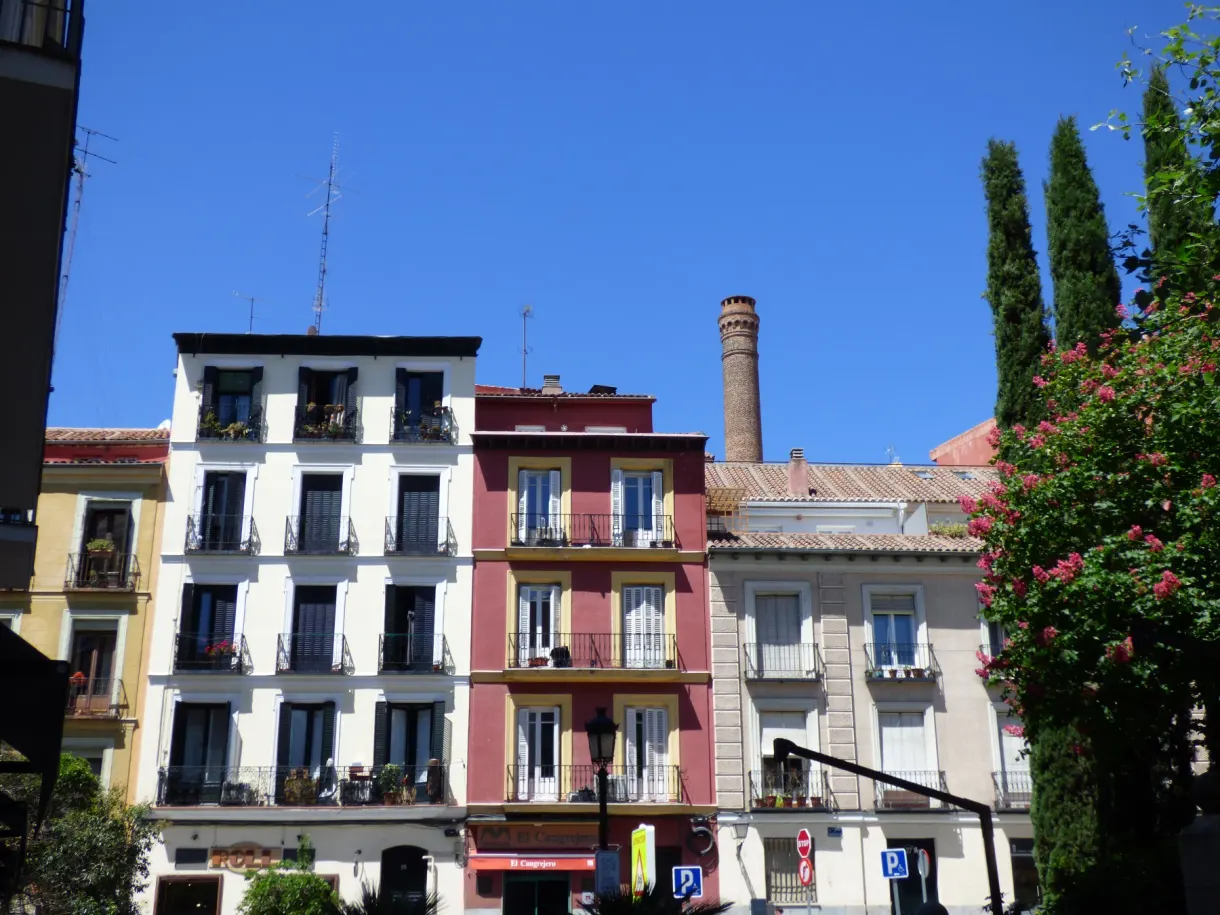 Colourful buildings with balconies and a tall brick chimney