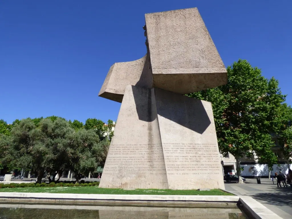 Monumental concrete sculpture set near a pond