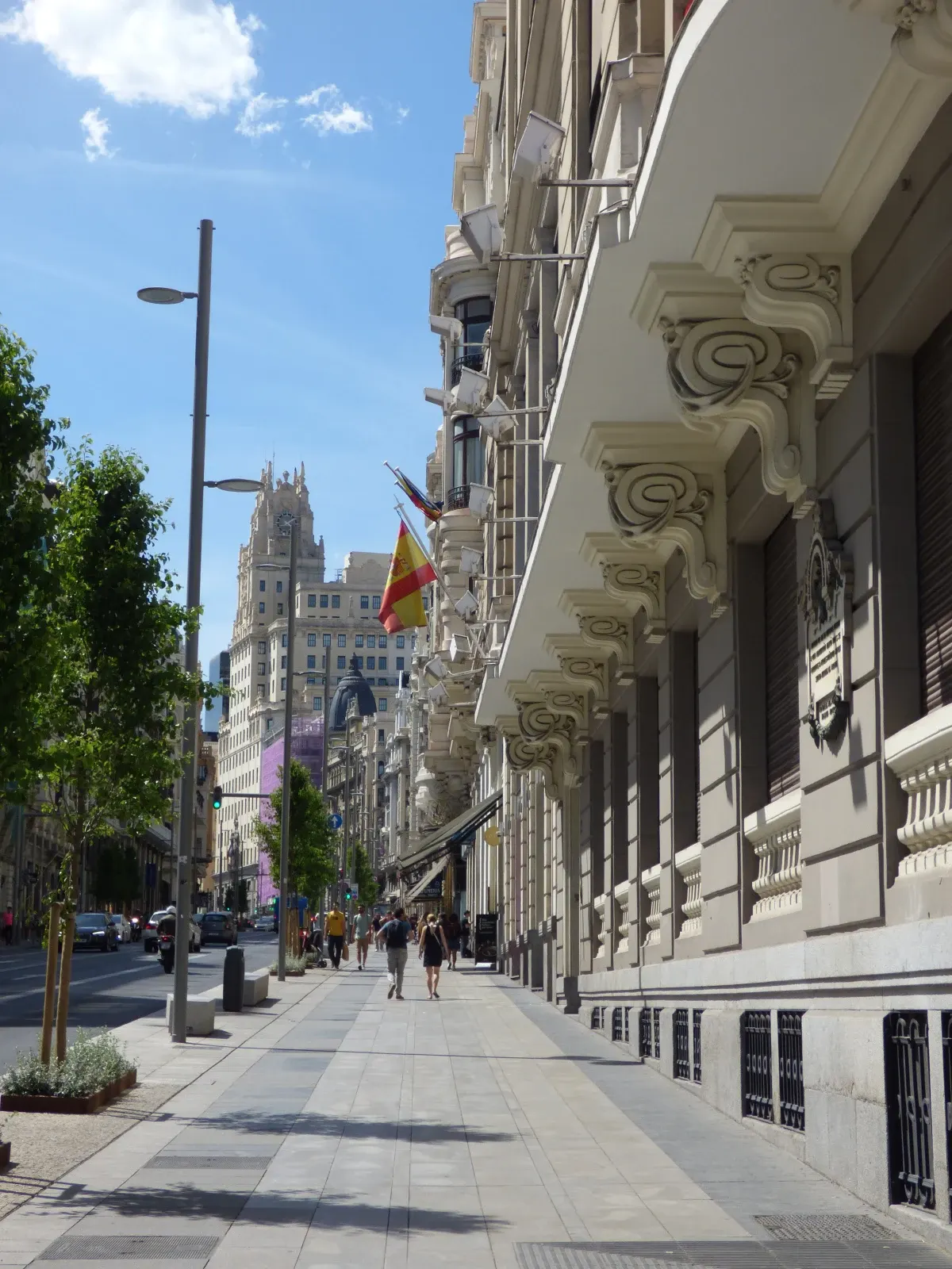 Sunlit pavement running along tall ornate facades