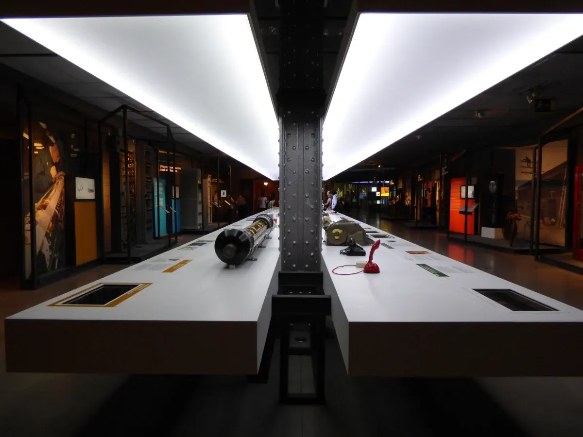 Objects lined up beneath the light strips of a gallery