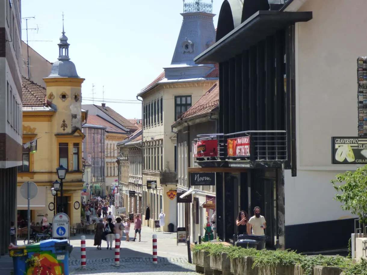 Busy shopping street dominated by a yellow tower
