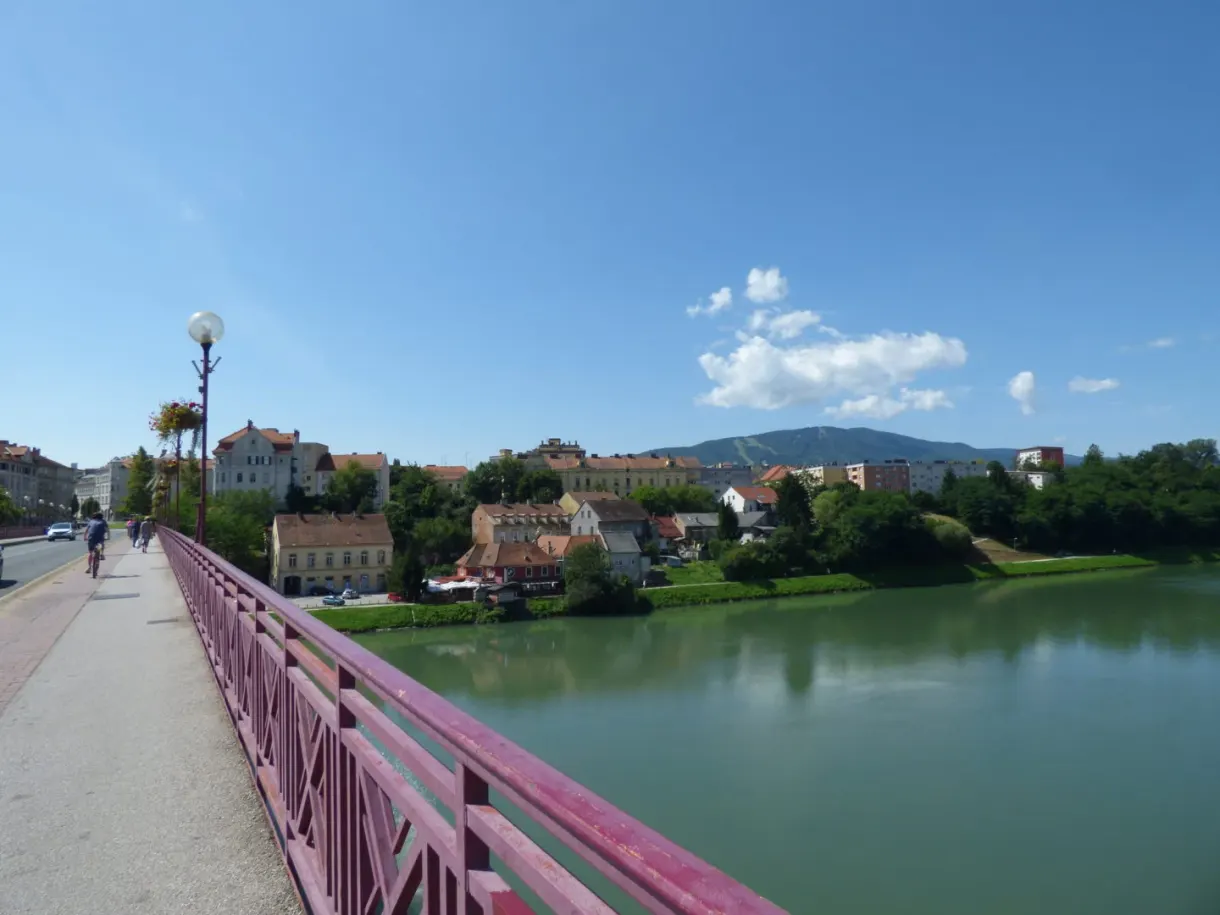 From a pink bridge, the river and the wooded hills