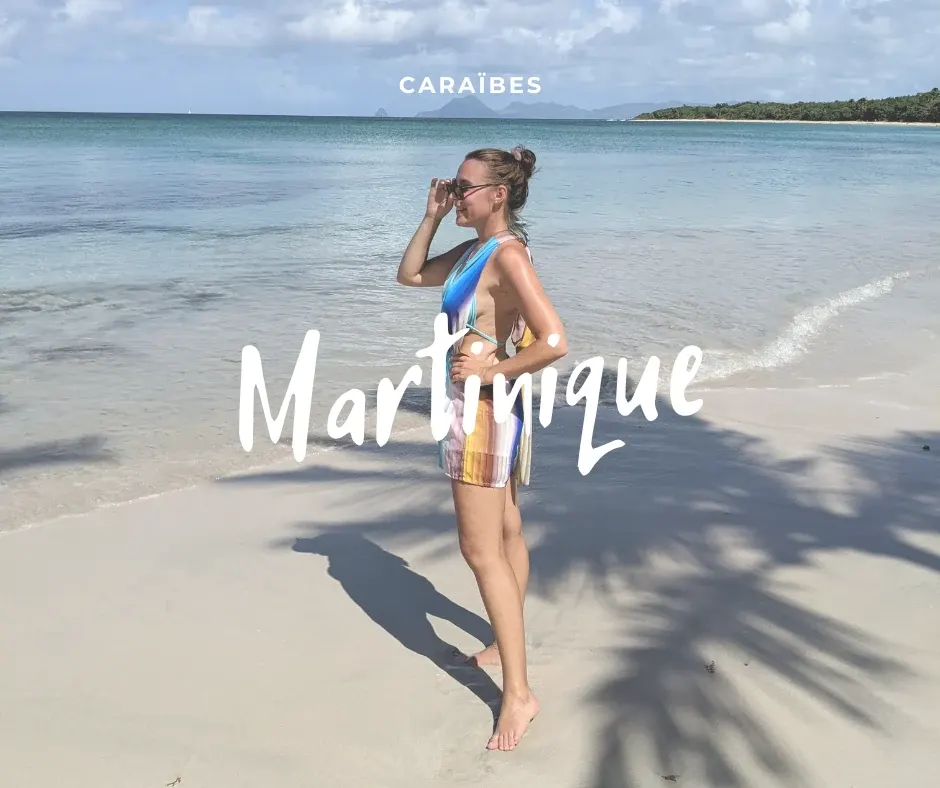 Femme en maillot au bord d'une plage de sable blanc, eau turquoise