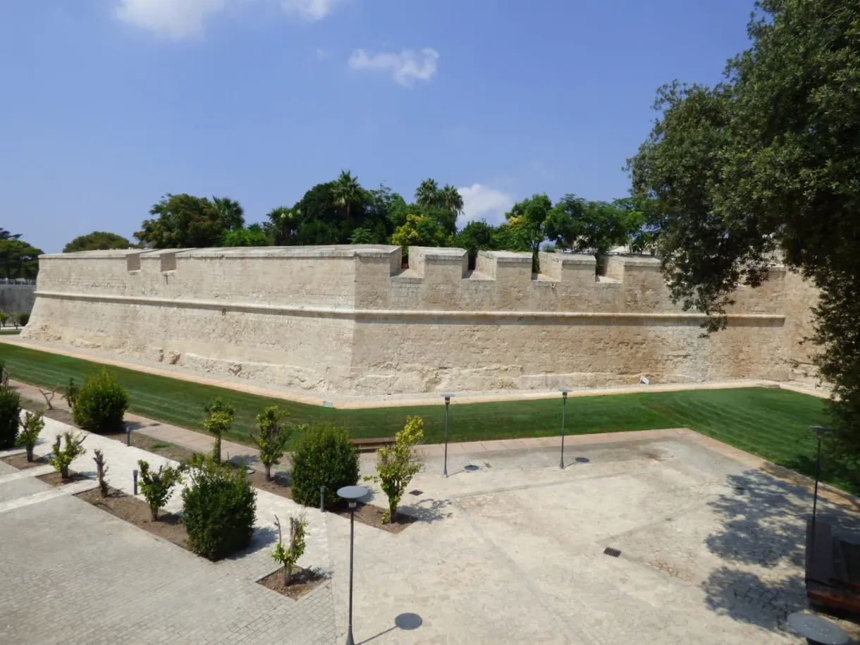 Remparts de pierre dorée bordés d'une pelouse tondue