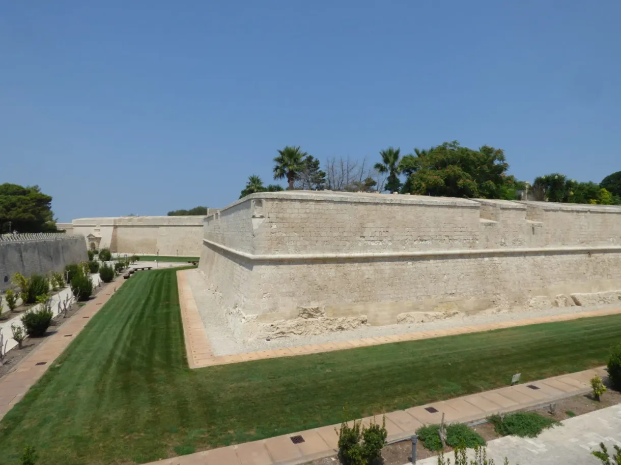 Bastion en angle et palmiers au-dessus des fossés verdoyants