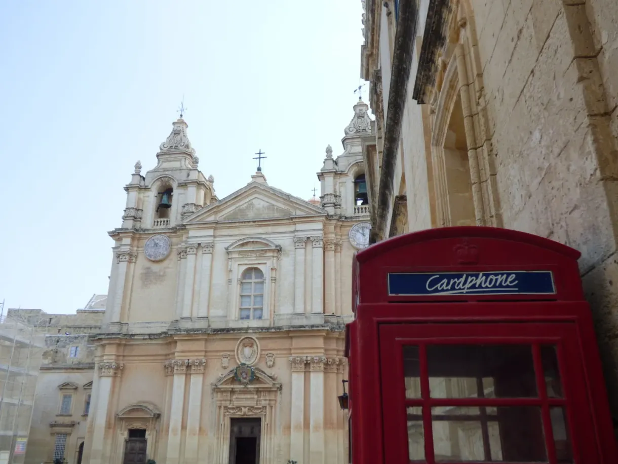 Cabine téléphonique rouge devant les tours de la cathédrale