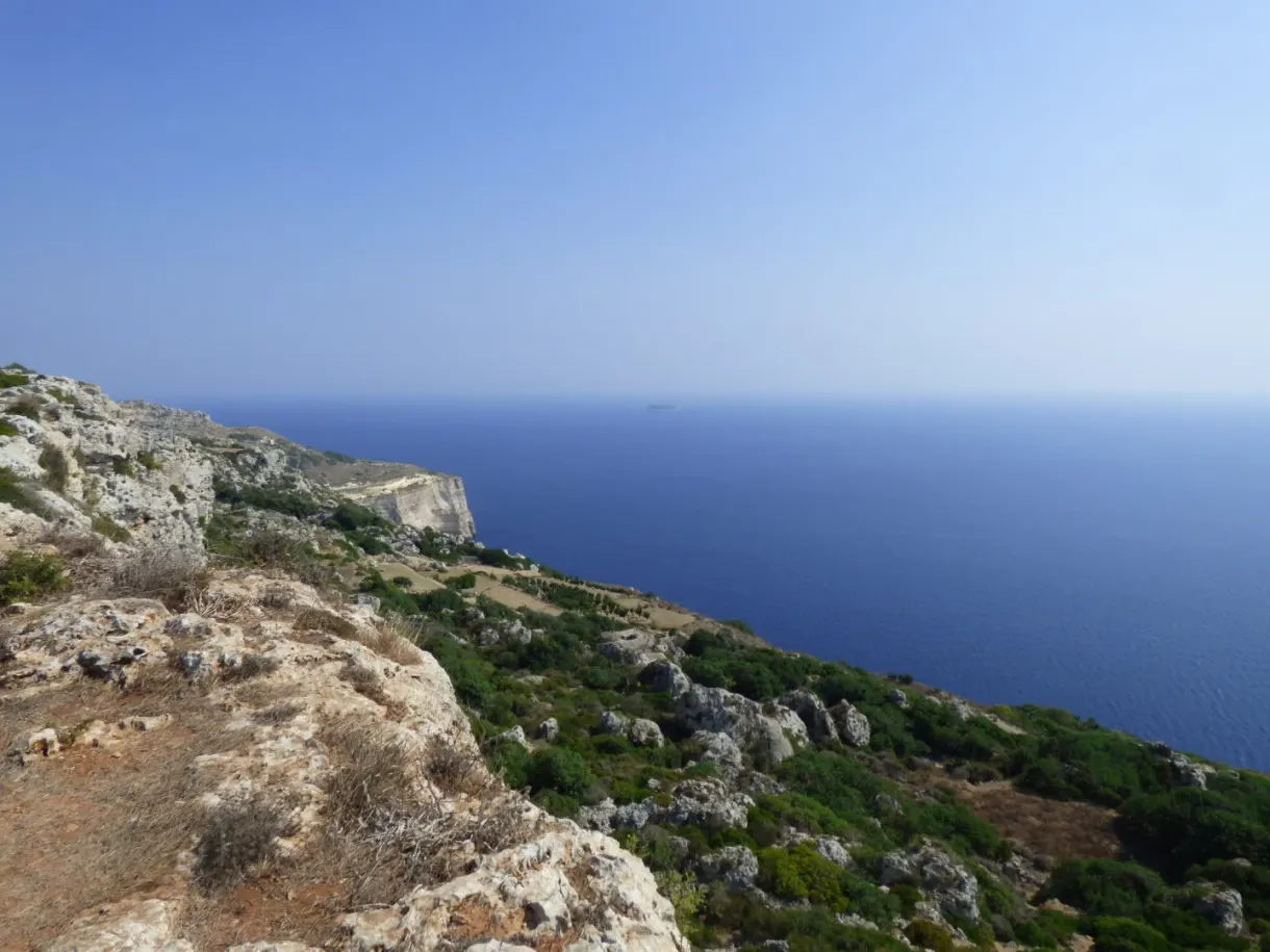 Arête rocheuse dominant une mer d'un bleu profond