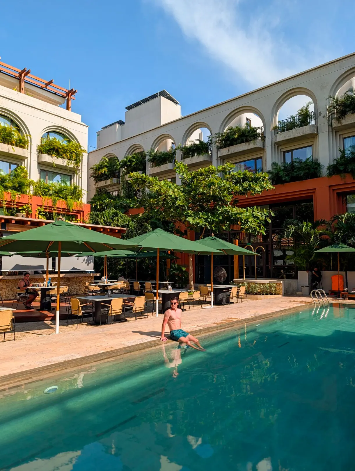 Romain by the pool of a partner hotel with arches and hanging gardens