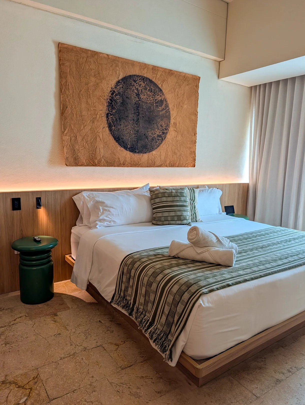 hotel room with sleek decor in beige and dark green tones