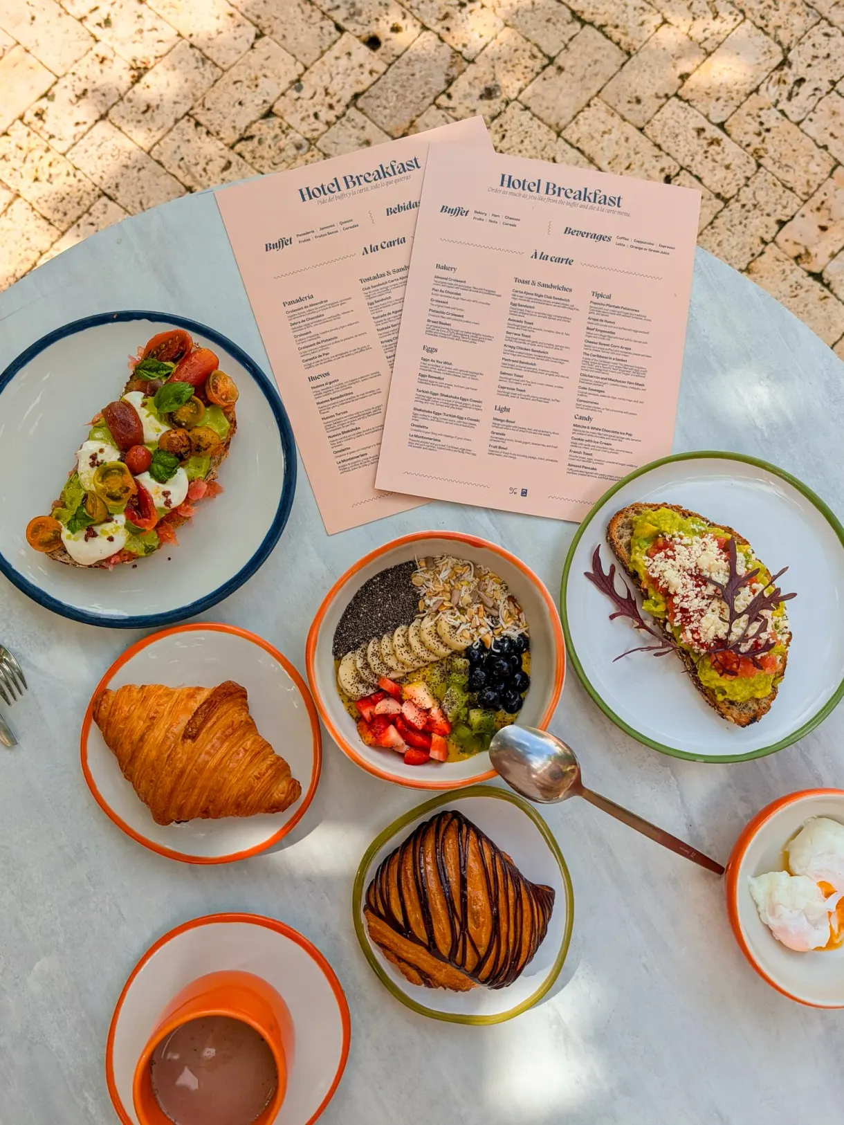 Hotel breakfast: avocado toast, a bowl of fresh fruit and pastries