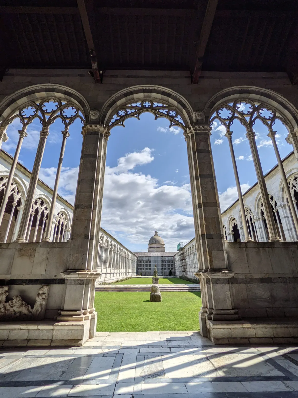 Gothic arcades opening onto the grassy courtyard of the Camposanto