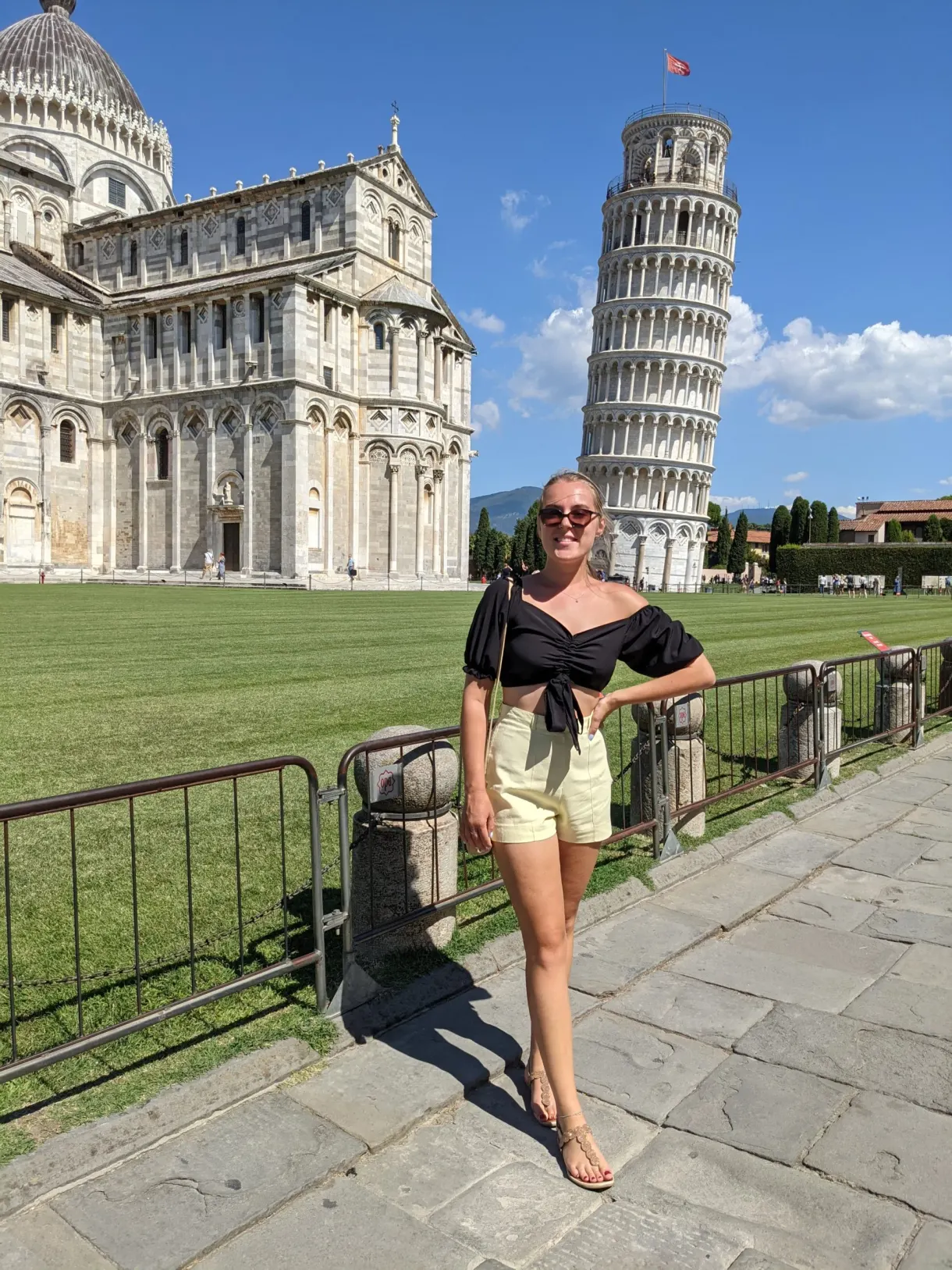 Woman posing in front of the leaning tower and the cathedral