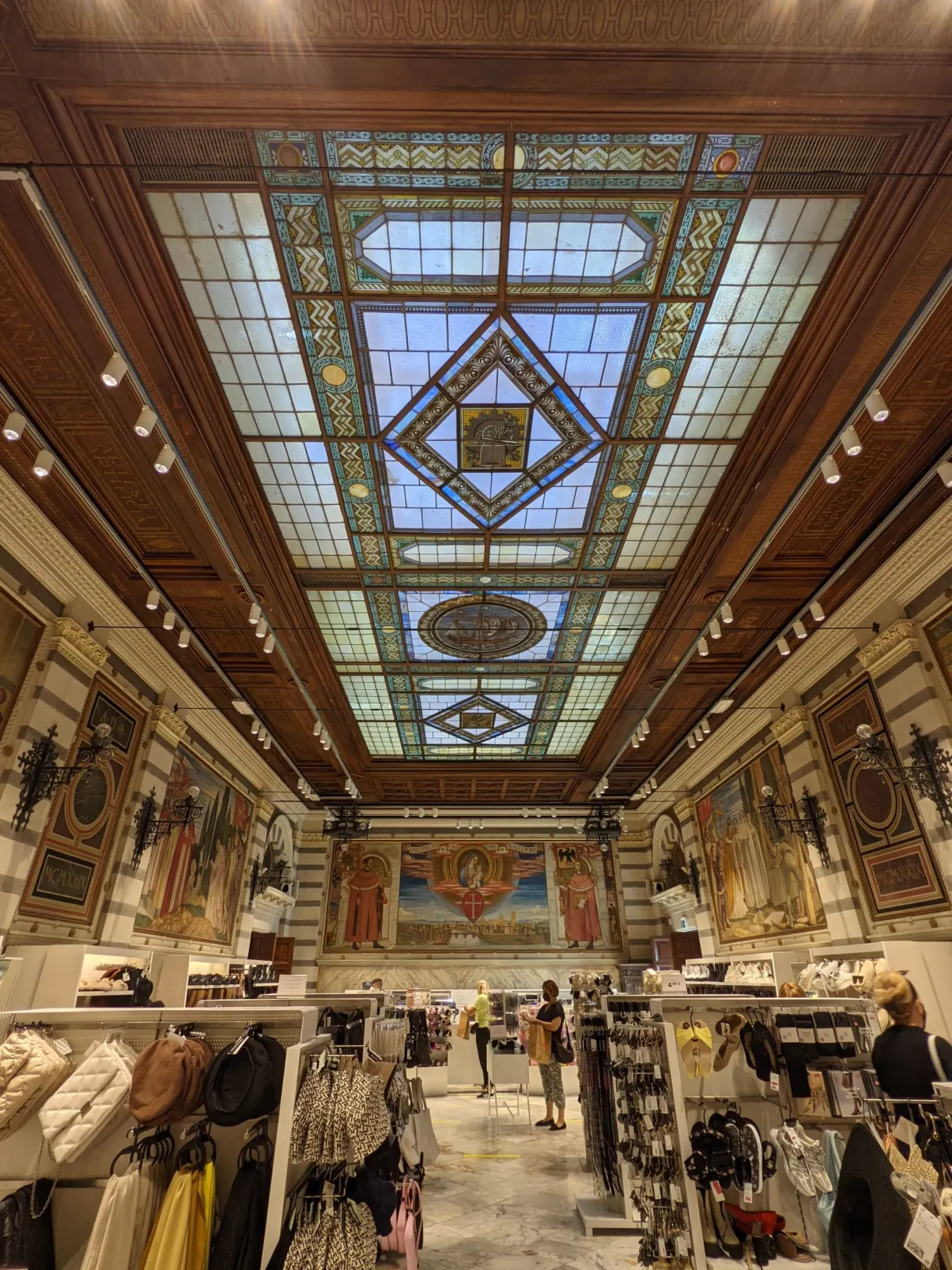 Stained glass ceiling above the display stands of a shop