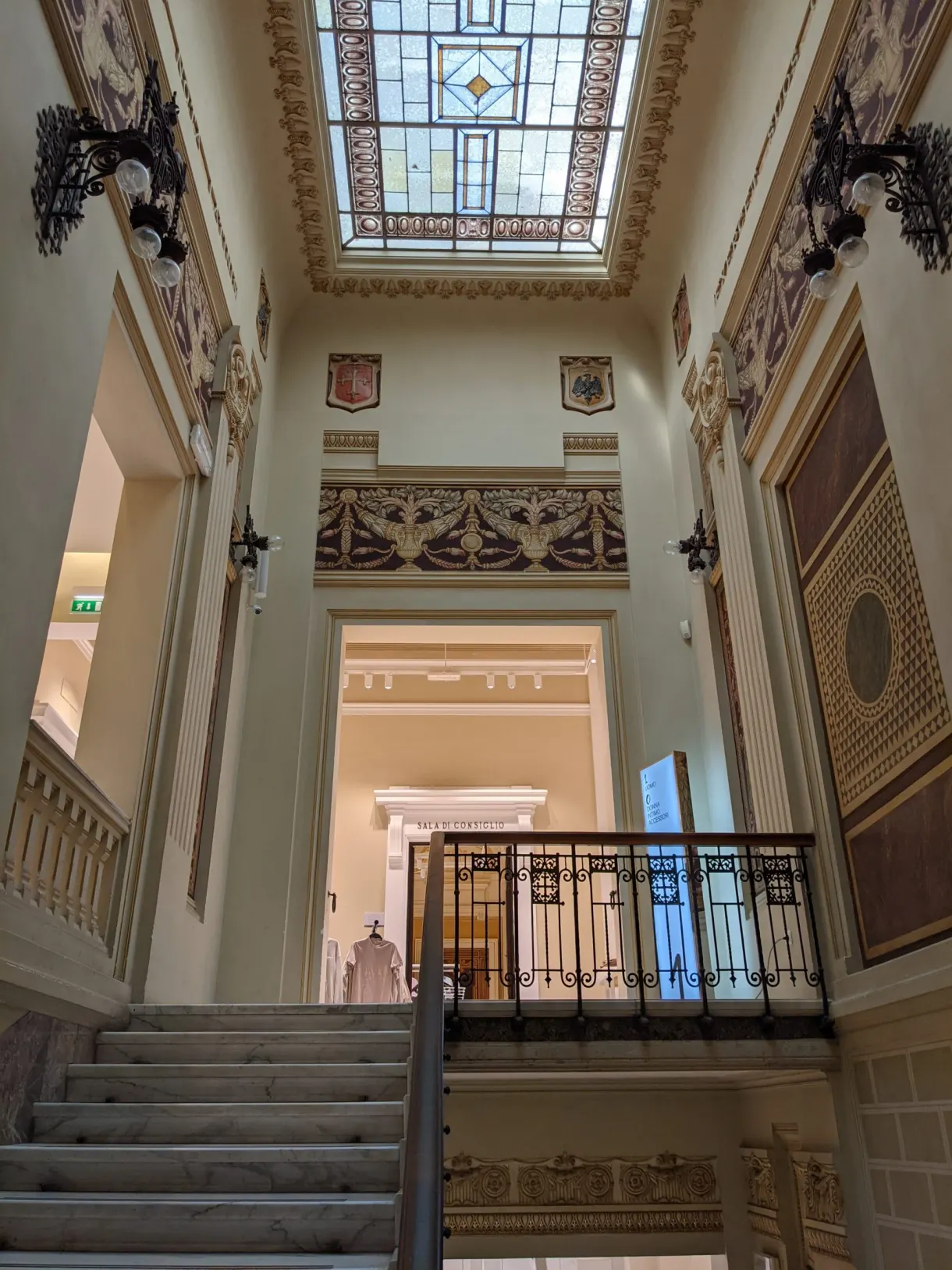 Marble staircase climbing towards a coloured glass roof